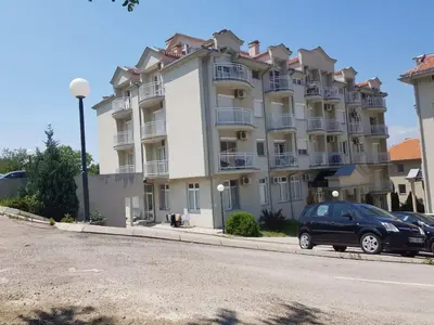 a large building with a car parked in front of it at Kragić apartman in Soko Banja
