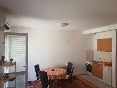 a kitchen with a table and chairs in a room at Kragić apartman in Soko Banja