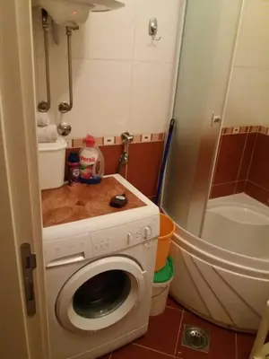 a bathroom with a washing machine and a shower at Kragić apartman in Soko Banja