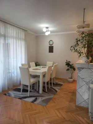 a dining room with a white table and chairs at LOTUS (dvosoban apartman) in Vrnjačka Banja