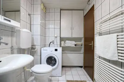a bathroom with a washing machine and a sink at LOTUS (dvosoban apartman) in Vrnjačka Banja