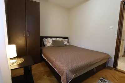 a small bedroom with a bed and a cabinet at LOTUS (dvosoban apartman) in Vrnjačka Banja