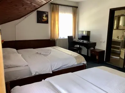 a hotel room with two beds and a desk with a computer at Sobe na Jošanici in Jošanička Banja