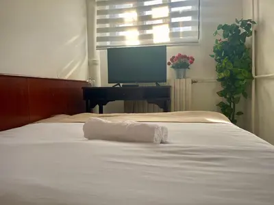 a bedroom with a white bed with a desk and a television at Sobe na Jošanici in Jošanička Banja