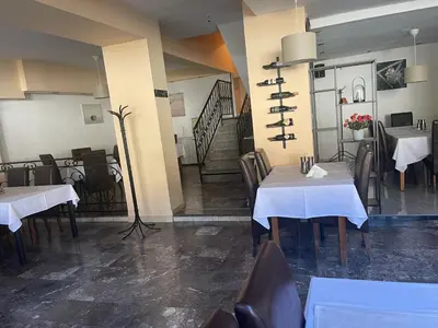 a restaurant with tables and chairs and a staircase at Sobe na Jošanici in Jošanička Banja