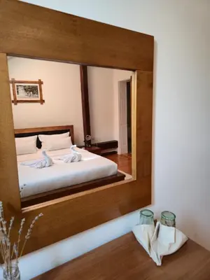 a mirror reflecting a bedroom with a bed in a room at Devedzic in Vrnjačka Banja