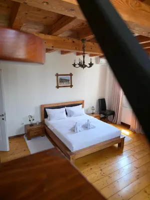 a bedroom with a large white bed with wooden floors at Devedzic in Vrnjačka Banja