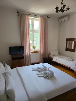 a bedroom with two beds with white sheets and a window at Devedzic in Vrnjačka Banja