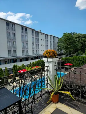 a balcony with tables and chairs and a building at Devedzic in Vrnjačka Banja