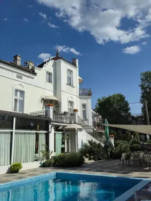 a large white house with a swimming pool in front of it at Devedzic in Vrnjačka Banja