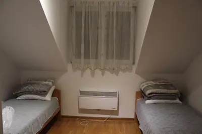 a attic bedroom with two beds and a window at Apartman ALEX LUX in Vrnjačka Banja