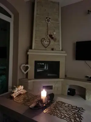 a room with a fireplace with a candle on a table at Apartman ALEX LUX in Vrnjačka Banja