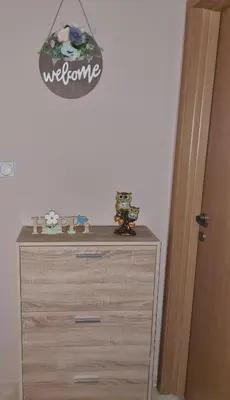 a dresser in a bedroom with a sign on the wall at Apartman ALEX LUX in Vrnjačka Banja