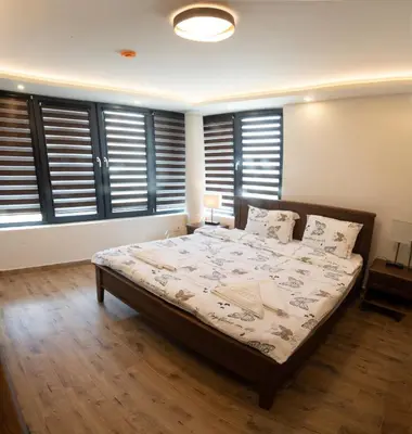 a bedroom with a bed in a room with windows at Zoo Misic Prenoćište in Vranje