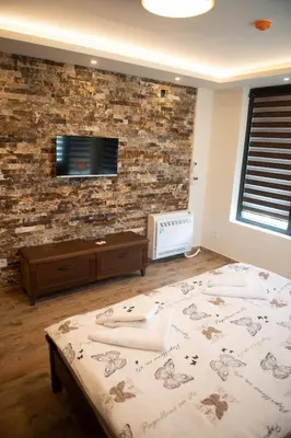 a bedroom with a bed and a brick wall at Zoo Misic Prenoćište in Vranje