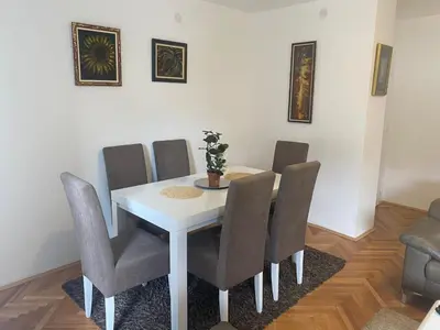 a dining room table with chairs and a white table at Sandra in Niš