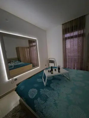a bedroom with a bed and a large mirror at J&A Apartman in Jagodina