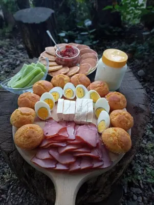a plate of food with meat and other foods on a table at Konaciste Mali Izvor in Boljevac