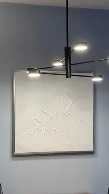 a picture hanging on a wall with a chandelier at Five-O-Six Apartment, Župa-Kopaonik in Kopaonik
