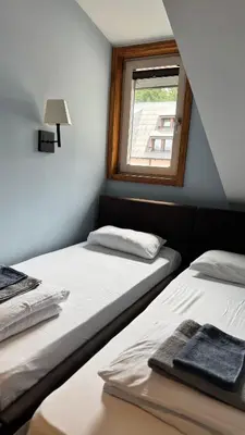 two beds in a room with a window at Five-O-Six Apartment, Župa-Kopaonik in Kopaonik