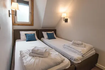 two beds in a room with blue pillows on them at Five-O-Six Apartment, Župa-Kopaonik in Kopaonik