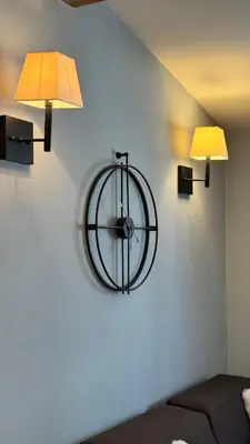 a clock on a wall with two lights on it at Five-O-Six Apartment, Župa-Kopaonik in Kopaonik