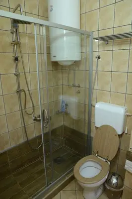a bathroom with a glass shower with a toilet at Studio Apartman Dunja in Jagodina