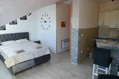 a bedroom with a bed and a clock on the wall at Studio Apartman Dunja in Jagodina
