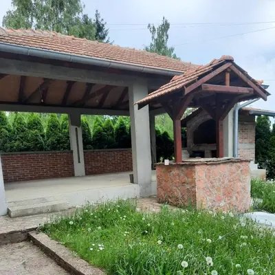 a wooden pavilion with a brick building at Apartman Vista in Soko Banja