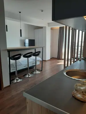 a kitchen with a counter and two bar stools at Vihor A21 in Kopaonik