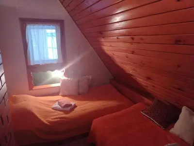 a small room with a bed with a window at Vila Lara in Kopaonik