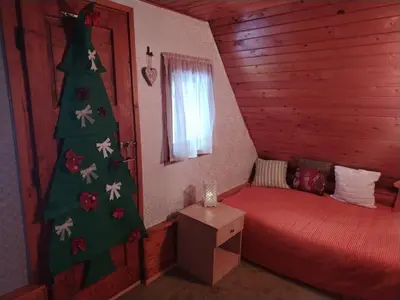 a bedroom with a christmas tree next to a bed at Vila Lara in Kopaonik