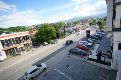 a city street with cars parked in a parking lot at Apartman Elena 11 in Vrnjci