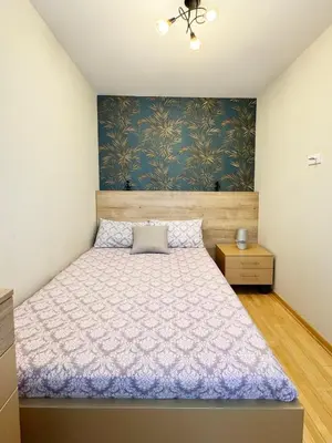 a bedroom with a bed and a blue wall at Apartman Elena 11 in Vrnjci