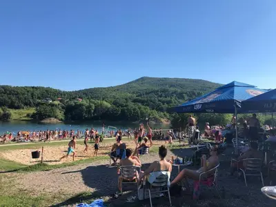 a group of people sitting in chairs on a beach at Apartmani Plaža in Bor