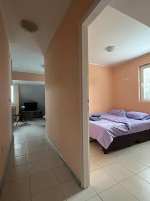 a bedroom with a bed and a living room at Apartmani Plaža in Bor