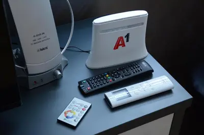 a computer and a remote control on a table at Apartman Jocić in Vrnjačka Banja