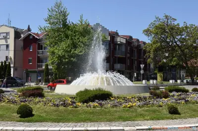 a fountain in the middle of a park with flowers at Apartman Jocić in Vrnjačka Banja