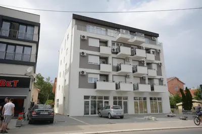 a building with cars parked in front of it at Apartman Jocić in Vrnjačka Banja