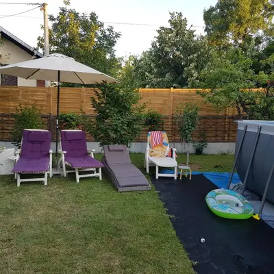 a patio with purple chairs and an umbrella and a frisbee at Apartmani Filipi in Vrnjačka Banja