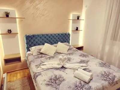 a bedroom with a blue bed with towels on it at Apartman Ljubičica in Vrnjačka Banja