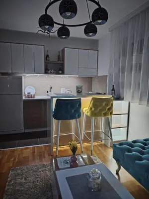 a kitchen with two chairs and a table in a room at Apartman Ljubičica in Vrnjačka Banja
