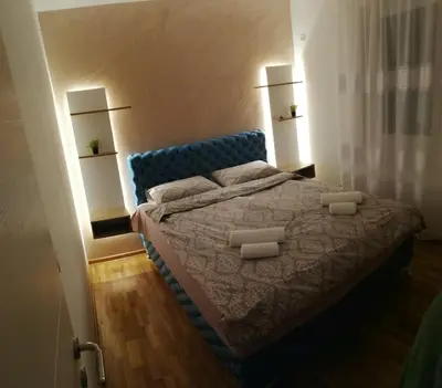 a bedroom with a blue bed with two pillows at Apartman Ljubičica in Vrnjačka Banja