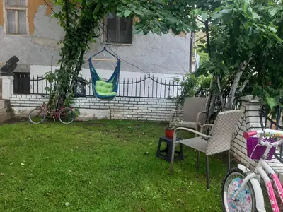a yard with chairs and a hammock hanging from a fence at Vila Mir in Pirot
