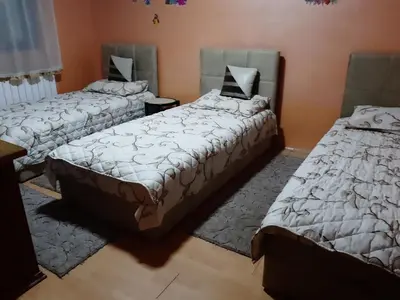 a room with three beds and a rug at Vila Mir in Pirot