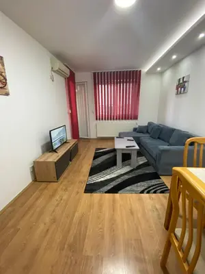 a living room with a blue couch and a tv at Apartman Kasija in Jagodina