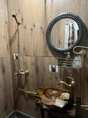 a wooden bathroom with a wooden toilet and a mirror at VILA MILICA & SPA ALEKSANDRA in Dimitrovgrad