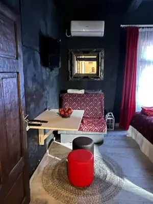 a living room with a red couch and a table at VILA MILICA & SPA ALEKSANDRA in Dimitrovgrad