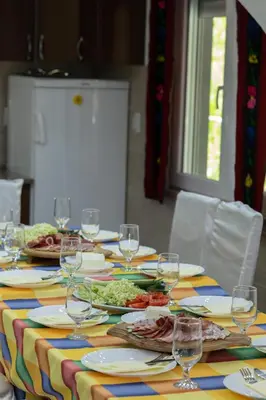 a table with plates of food and wine glasses at Vila Dimitrijevic Lisine in Despotovac