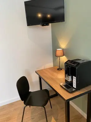 a room with a table with a microwave and a chair at Bonanza Apartments in Niš